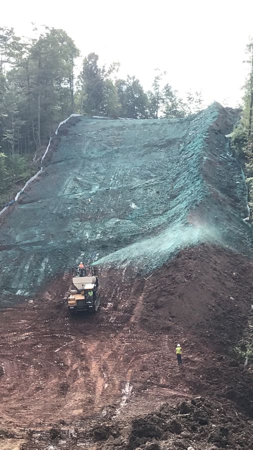 Tracked hydroseeder seeding a steep restored slope