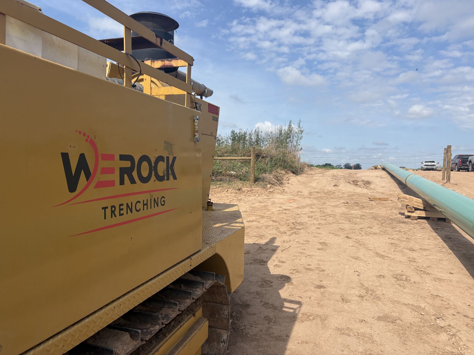 We Rock Trenching Trencor on the right-of-way with pipe strung behind it